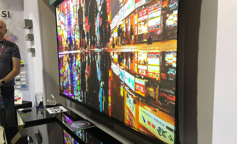 Screen Innovations 100” Solo screen is an ALR type designed for UST projectors.  Shown here at CEDIA, under lots of trade show ambient light.  The projector an Epson LS500. Vibrant colors!